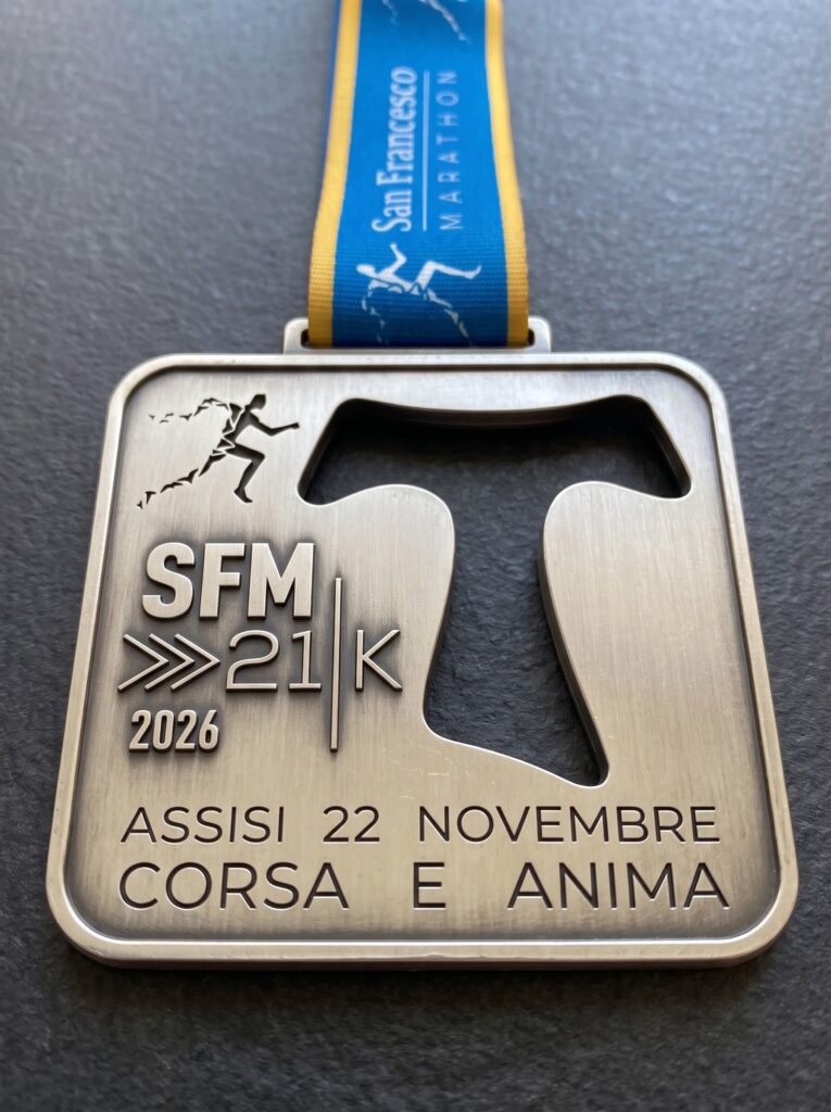 Medaglia della 21K San Francesco Marathon 2026 con il Tau traforato